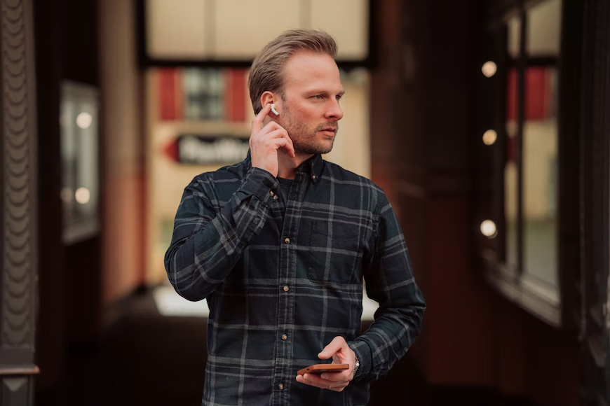 man wearing one AirPod piece on his left ear